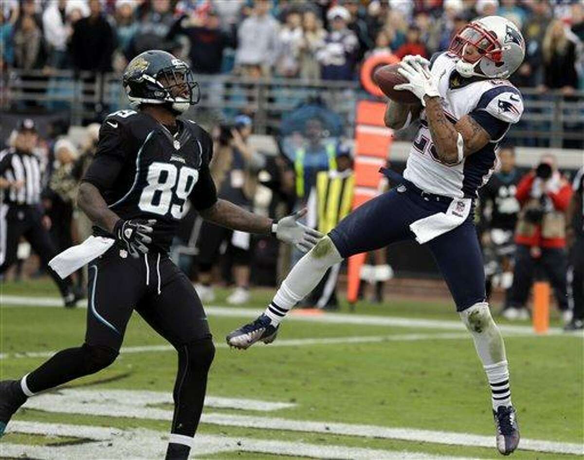 New England Patriots free safety Patrick Chung, right, intercepts a pass in front of Jacksonville Jaguars tight end Marcedes Lewis (89) as time expires in an NFL football game on Sunday, Dec. 23, 2012, in Jacksonville, Fla. New England won the game 23-16. (AP Photo/John Raoux)