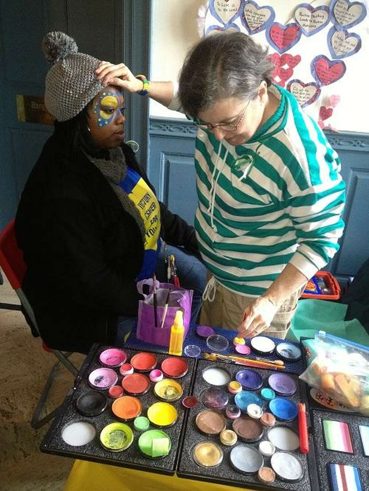 Pictured with painter Robbie Pack is Ericka Taylor of Pittsburgh, Pa. Pack, of Fairfield, Conn., came to Newtown to lift spirits by painting faces. Taylor came to Newtown with a friend to do outreach with Victory Center for Youth, of Cleveland.