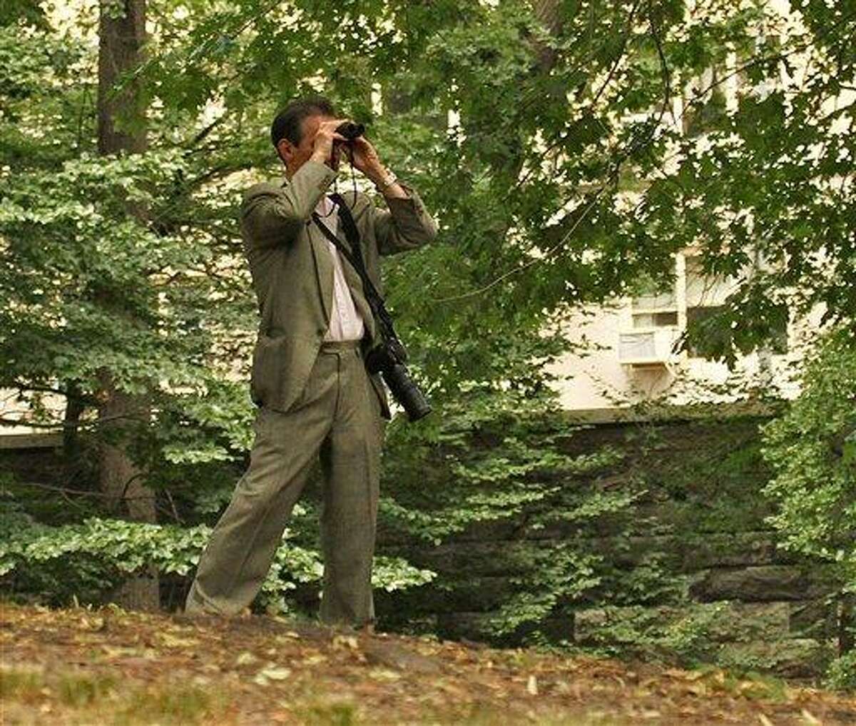 In this June 30, 2012 photo provided by Jean Shum, Jeffrey Johnson uses binoculars to search New York's Central Park for the young offspring of a popular red-tailed Hawk that local birdwatchers know as Pale Male. On Friday, Aug. 24, 2012, Johnson killed a former employer outside the Empire State Building in New York and was himself killed shortly afterwards by police. Nine bystanders were wounded in that chaotic confrontation. (AP Photo/Jean M. Shum) MANDATORY CREDIT