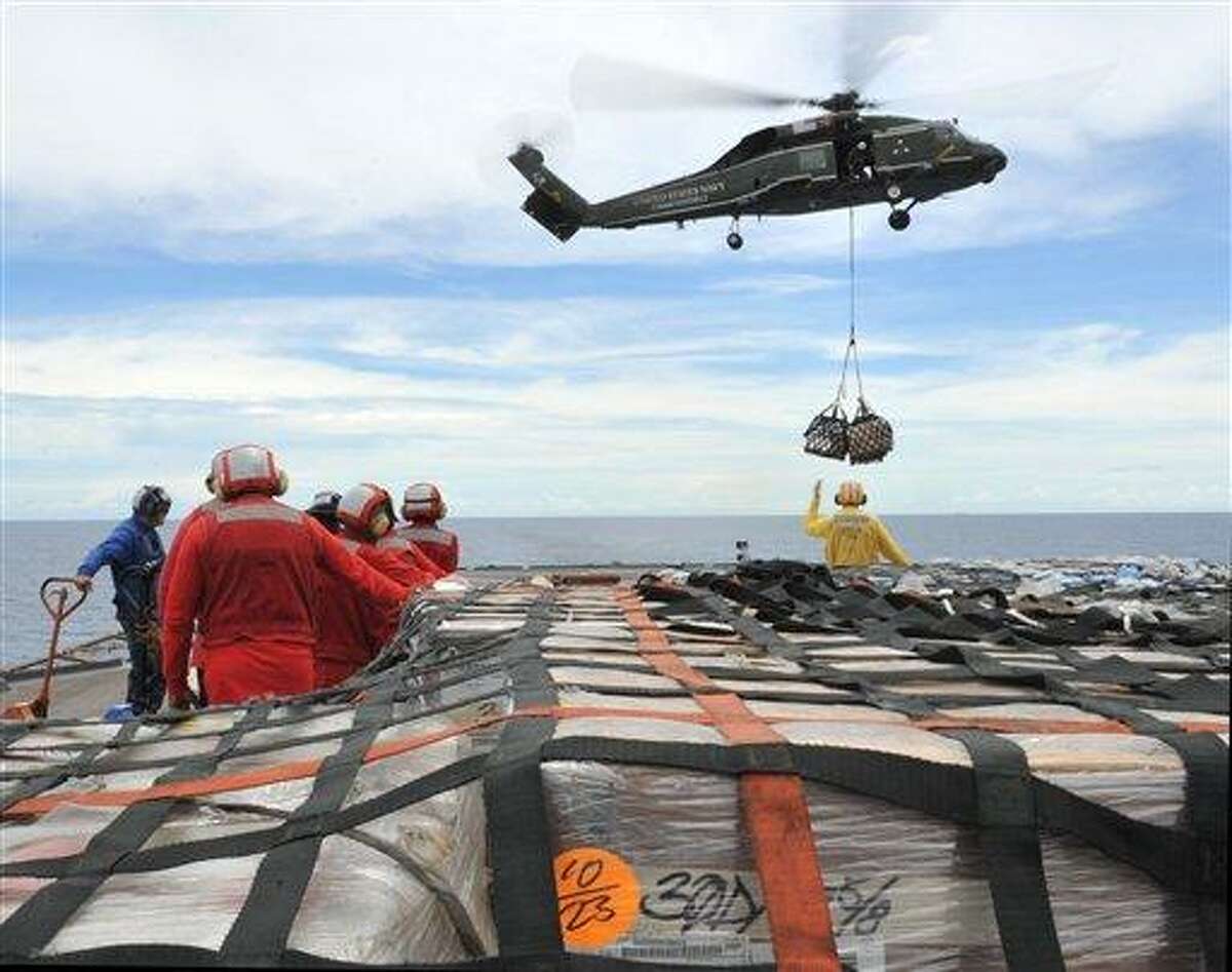 In this March 12, 2011 photo provided by the U.S. Navy, sailors aboard the U.S. 7th Fleet command ship USS Blue Ridge (LCC 19) stand-by to move pallets of humanitarian relief supplies across the ship's flight deck during an underway replenishment with the Military Sealift Command fleet replenishment oiler USNS Rappahannock (T-AO 204), not pictured. Blue Ridge was ensuring the crew was ready if directed to assist with earthquake and tsunami relief operations in Japan. (AP Photo/U.S. Navy, Fidel C. Hart)