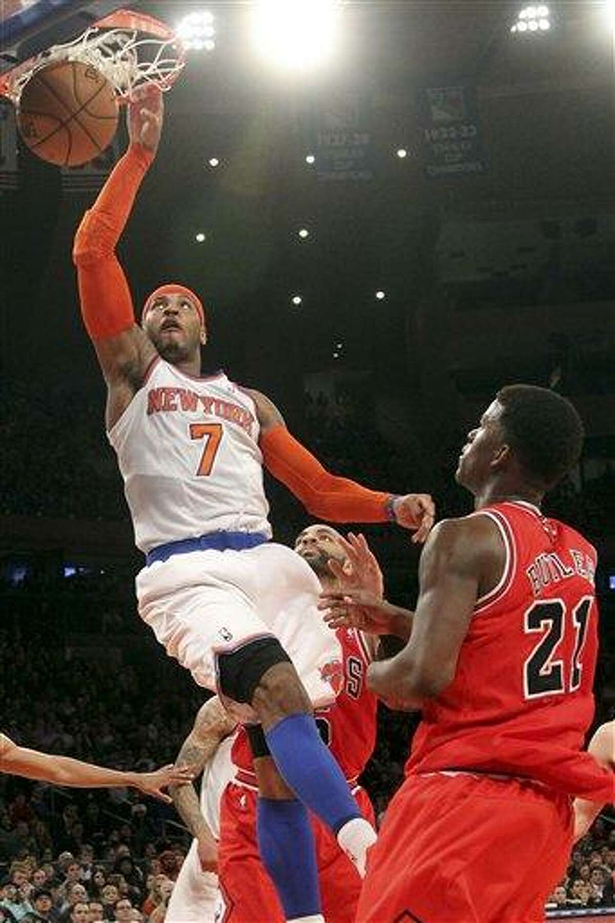 Chicago Bulls' Jimmy Butler (21) watches as New York Knicks' Carmelo Anthony scores a basket during the first half of an NBA basketball game on Friday, Dec. 21, 2012, at Madison Square Garden in New York. (AP Photo/Mary Altaffer)