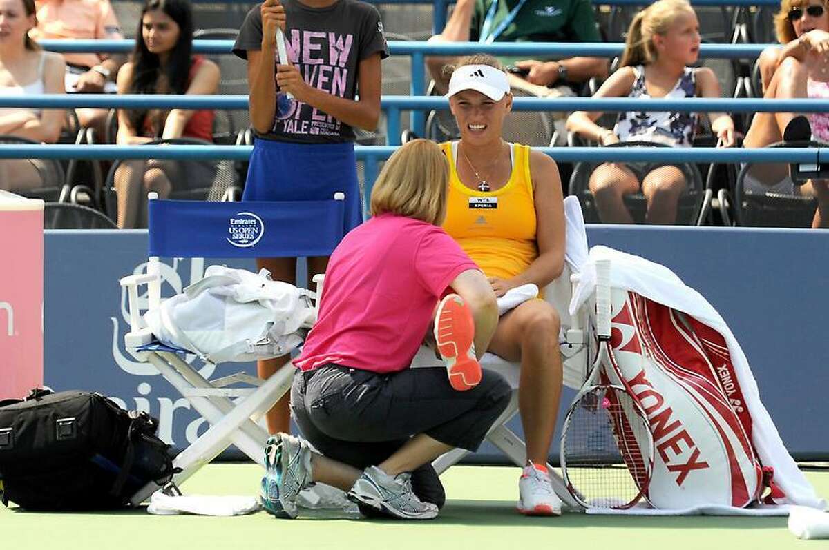Caroline Wozniacki receives treatment for her knee during her quarterfinal singles match at the New Haven Open Thursday, Aug. 23, 2012. (Bob Child/Special to the Register)