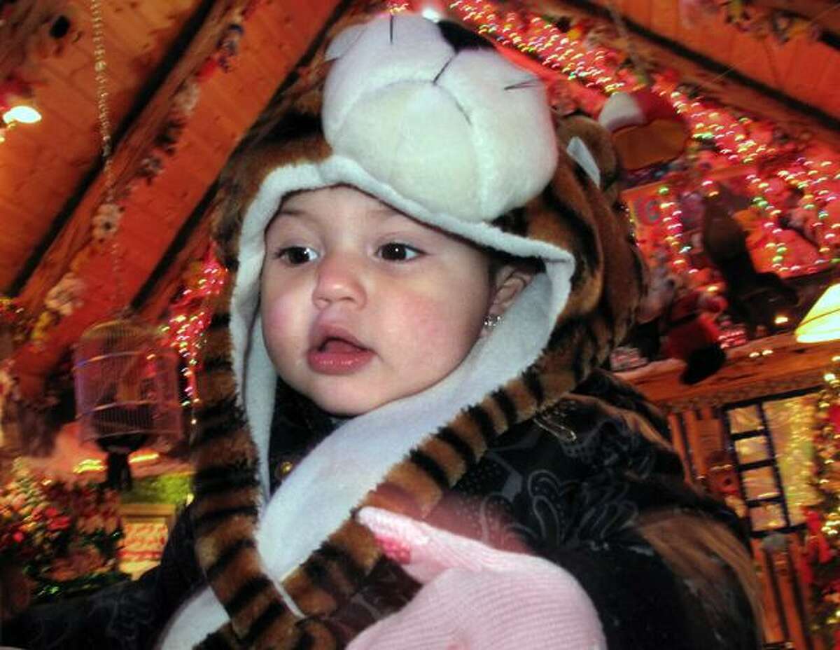DEBBI MORELLO/ Register Citizen Gianna Banores, 19 mos., visits the Toy House at Christmas Village on Sunday.