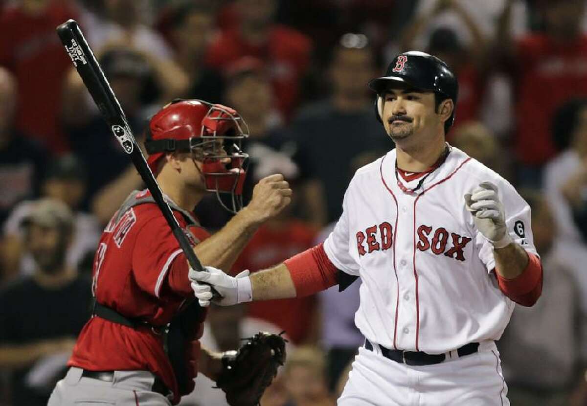 ASSOCIATED PRESS Boston Red Sox first baseman Adrian Gonzalez, right, reacts as he strikes out swinging to end the game as Los Angeles Angels catcher Chris Iannetta pumps Thursday night at Fenway Park in Boston. Gonzalez was scratched from the lineup Friday night as trade talks swirled between the Red Sox and Los Angeles Dodgers.