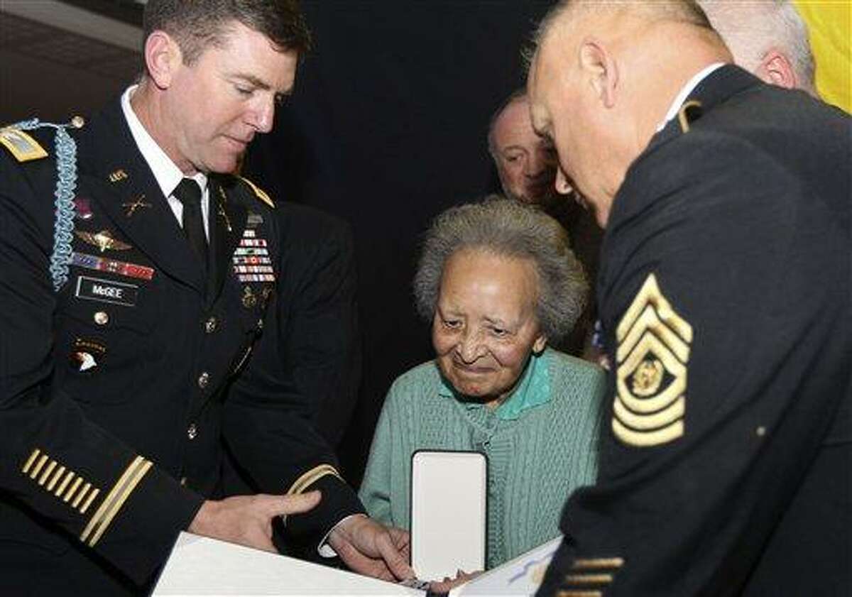 Belgian nurse Augusta Chiwy, center, who saved hundreds of wounded GIs during the WWII Battle of the Bulge, receives an award for valor from the U.S. Army, in Brussels Monday. The U.S. ambassador says there was a 67-year delay in presenting the award because it was assumed that Augusta Chiwy had herself perished in the battle. Associated Press