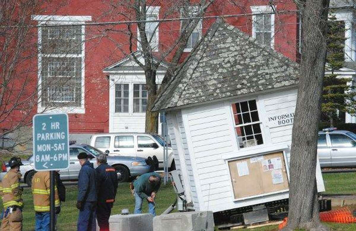 MIKE AGOGLIATI/ Register Citizen An information booth was knocked off of its foundation Saturday after a driver struck it and then a tree on the Litchfield Green.