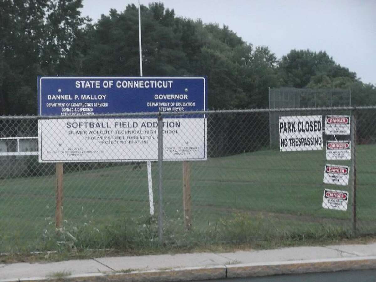 KEVIN D. ROBERTS/Register Citizen Signs posted on the property fence at Oliver Wolcott Technical High School warn people to not trespass on the athletic fields while they are under renovation. The large sign is from the State of Connecticut and details the ongoing project.