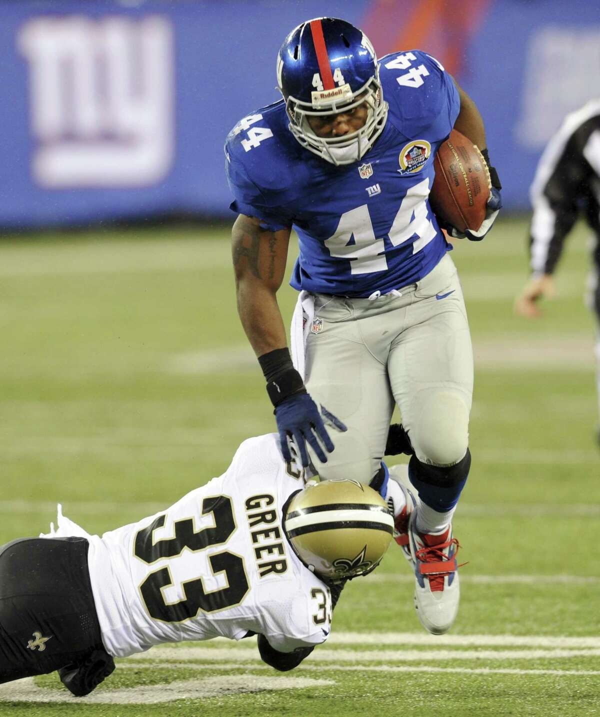 New Orleans Saints cornerback Jabari Greer (33) attempts to bring down New York Giants running back Ahmad Bradshaw (44) during the first half of an NFL football game Sunday, Dec. 9, 2012, in East Rutherford, N.J. (AP Photo/Bill Kostroun)