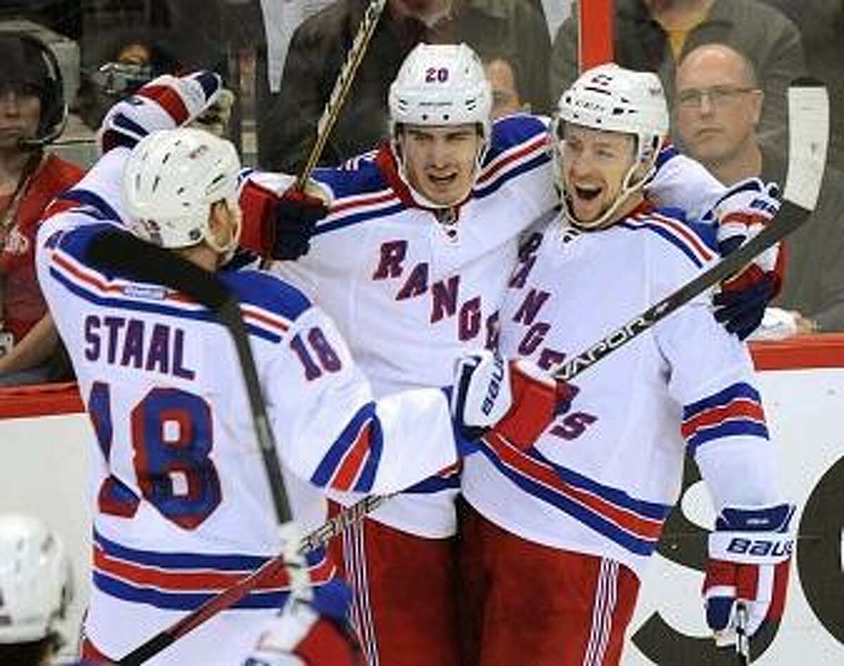 New York Rangers' Chris Kreider celebrates a goal with teammates Marc Staal, left, and Derek Stepan, right, against the Ottawa Senators during the second period of Game 6 of a first-round NHL Stanley Cup playoff hockey series, in Ottawa, Ontario, on Monday, April 23, 2012. (AP Photo/The Canadian Press, Sean Kilpatrick)