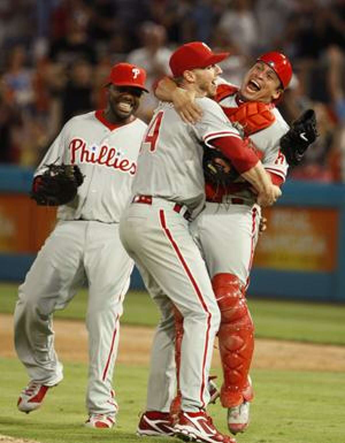 Philadelphia Phillies starting pitcher Roy Halladay, center, celebrates with Carlos Ruiz, right, and Ryan Howard after Halladay threw a perfect game during a baseball game against the Florida Marlins, Saturday, May 29, 2010 in Miami. The Phillies defeated the Marlins 1-0. (AP Photo/Wilfredo Lee)