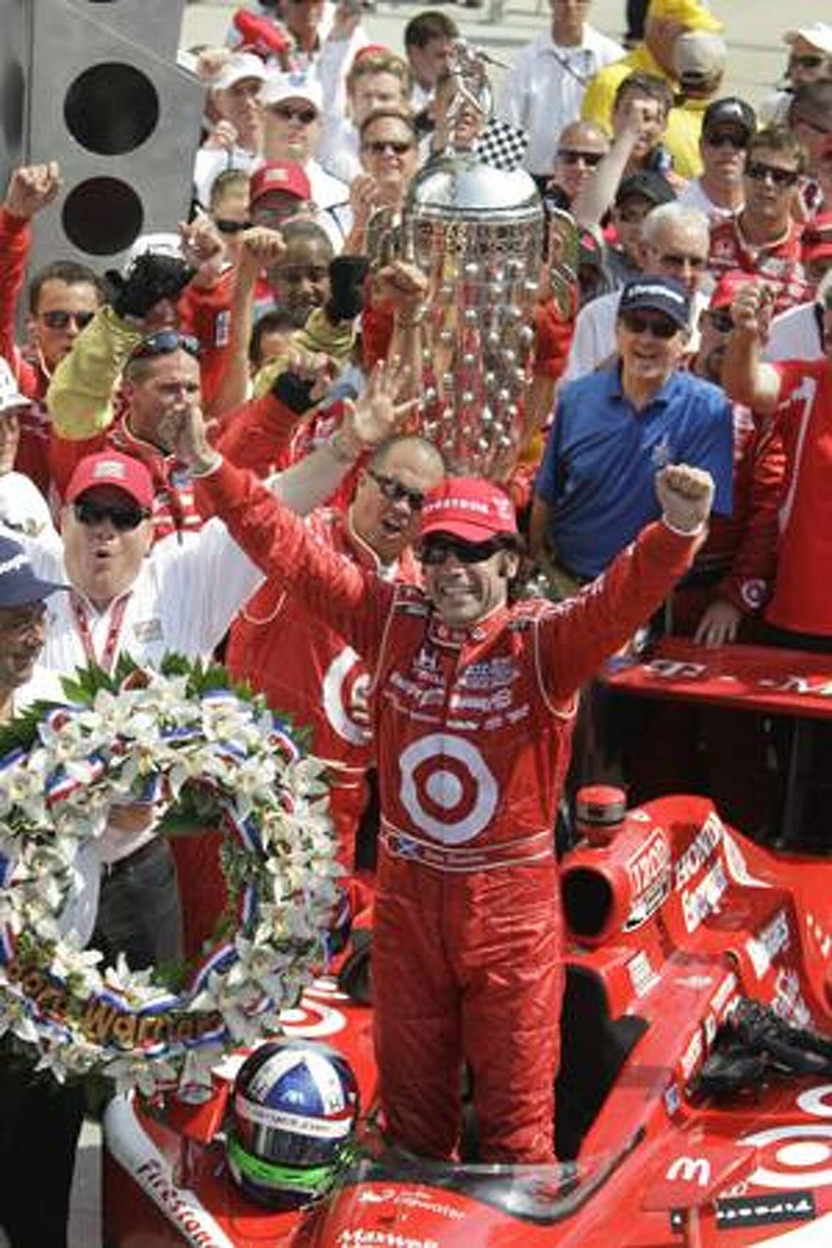 Dario Franchitti, of Scotland, celebrates after winning the Indianapolis 500 auto race at Indianapolis Motor Speedway in Indianapolis, Sunday, May 30, 2010. At left in white is team owner Chip Ganassi. At rear is the Borg-Warner Trophy. (AP Photo/Michael Conroy)