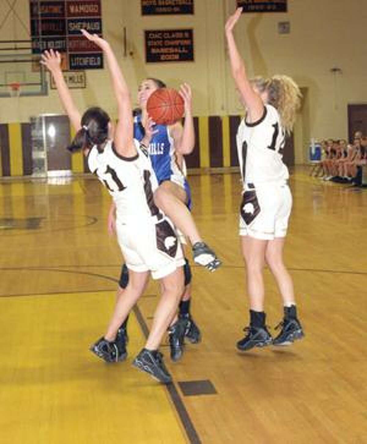 SONJA ZINKE/Register Citizen Lewis Mills' Kaitlin Niedmann goes up for a shot as Thomaston's Scarra Brandt defends during Wednesday's game in Thomaston. Purchase a glossy print of this photo and more at www.registercitizen.com.
