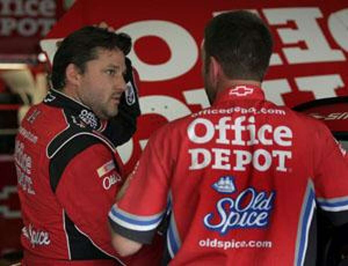 Tony Stewart, left, talks with a crew member during practice for Sunday's NASCAR Coca-Cola 600 at Lowe's Motor Speedway in Concord, N.C., Saturday. (AP Photo/Bob Jordan)