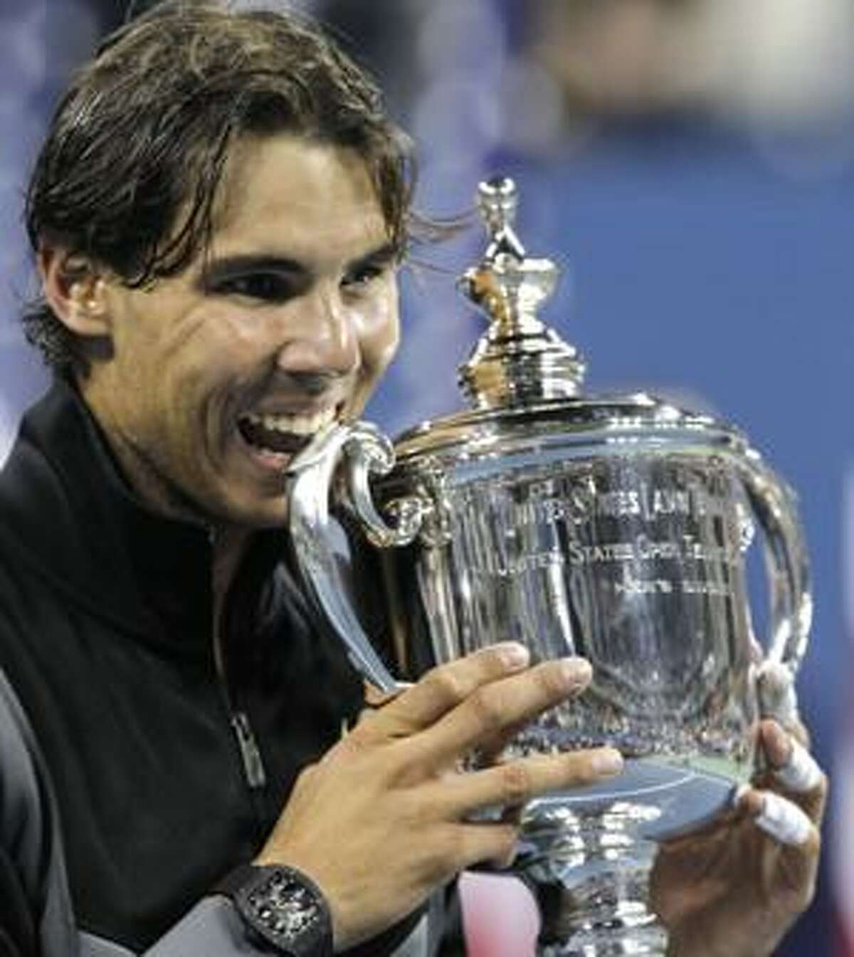 AP Rafael Nadal of Spain bites his trophy after beating Novak Djokovic of Serbia to win the men's championship match at the U.S. Open tennis tournament in New York, Monday.
