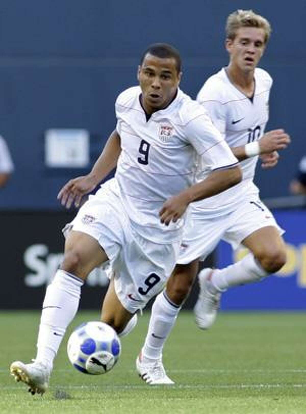 FILE - In this Oct. 13, 2009, file photo, United States' Charlie Davies, left, controls the ball as teammate Stuart Holden looks on during a CONCACAF Gold Cup soccer match against Grenada at Qwest Field in Seattle. Davies, sidelined since a accident last October, was omitted from the United States World Cup soccer training camp, US Soccer announced on Tuesday, May 11, 2010. (AP Photo/Ted S. Warren, File)
