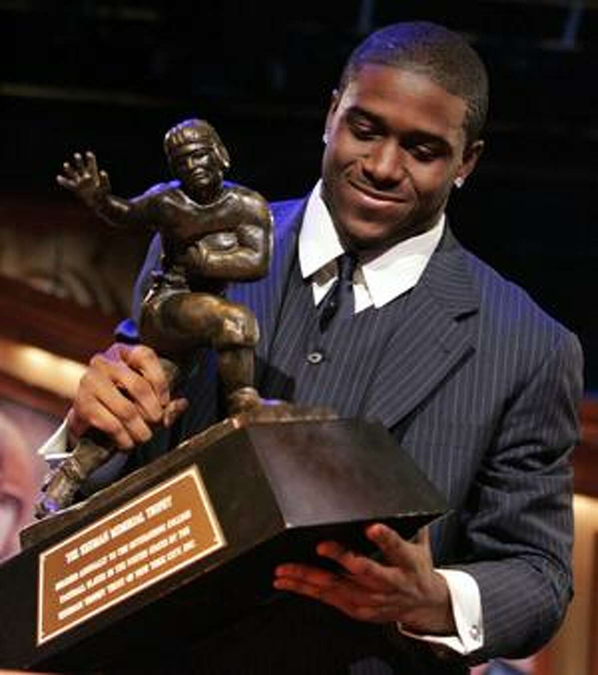 FILE - This Dec. 10, 2005, file photo shows Southern California tailback Reggie Bush pickimg up the Heisman Trophy after being announced as the winner of the award, in New York. Yahoo! Sports reported Tuesday, Sept. 7, 2010, that 2005 Heisman Trophy winner Reggie Bush is expected to be stripped of the award by the end of the month. The former Southern Cal running back would become the first player in the 75-year history of the award to have the Heisman Trophy taken away. (AP Photo/Julie Jacobson, File)