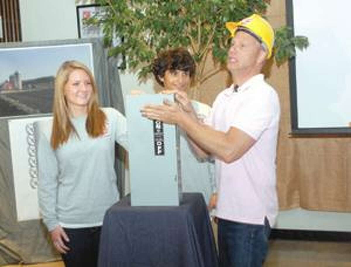 Northwestern Regional High School student representatives to the Board of Education, Shelby Mainville and Lior Trestman, assist tv personality Scott Haney in flipping the ceremonial switch for the school's new solar energy system on Thursday. Purchase a glossy print of this photo and more at www.registercitizen.com.