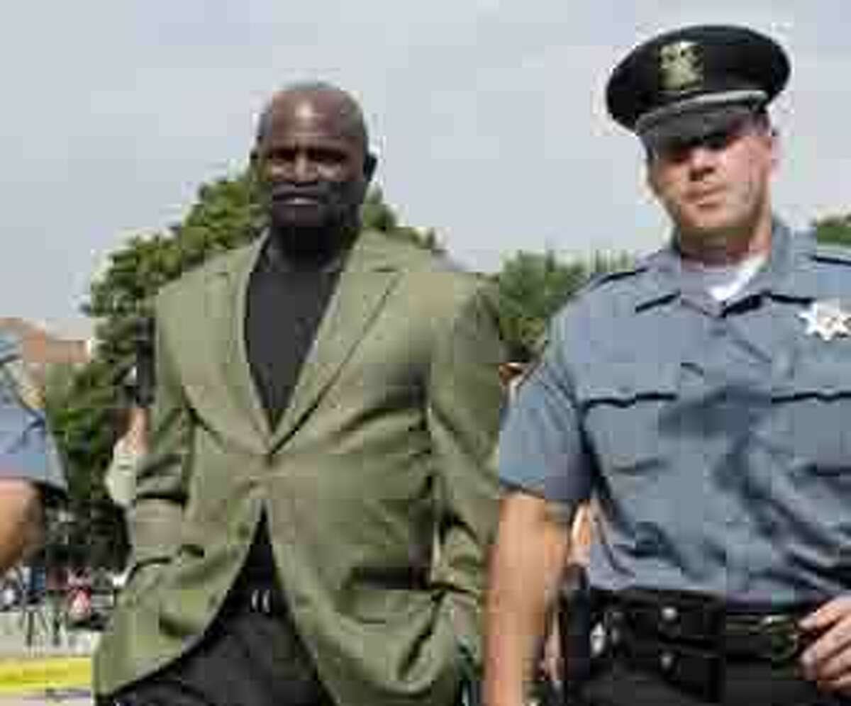 NFL Hall of Fame linebacker Lawrence Taylor, left, is accompanied by a Rockland County Sheriff's officer as he arrives for a court date in New City, N.Y., Tuesday, July 13, 2010. Taylor pleaded not guilty to charges that he had sex with a 16-year-old girl and to charges including third-degree rape, patronizing a prostitute and endangering a child. (AP Photo/Richard Drew)