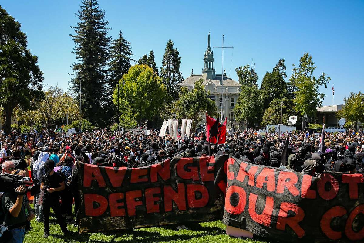 Hundreds of black-clad protesters make their way onto the lawn after police retreat during a protest at Martin Luther King Jr. Civic Center park in Berkeley, Calif., on Sunday, August 27th, 2017.