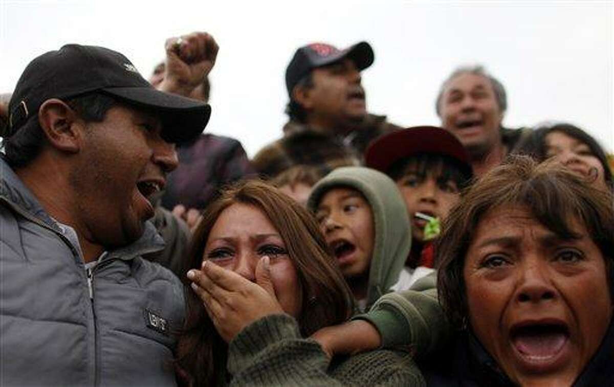 Roxana Gomez, center, daughter of miner Mario Gomez, reacts while watching on TV the rescue operations for her father as Maria Segovia, right, sister of trapped miner Dario Segovia, reacts at the camp outside the San Jose mine near Copiapo, Chile, Wednesday Oct. 13, 2010. The miners became trapped when the gold and copper mine collapsed on Aug. 5. (AP Photo/Natacha Pisarenko)
