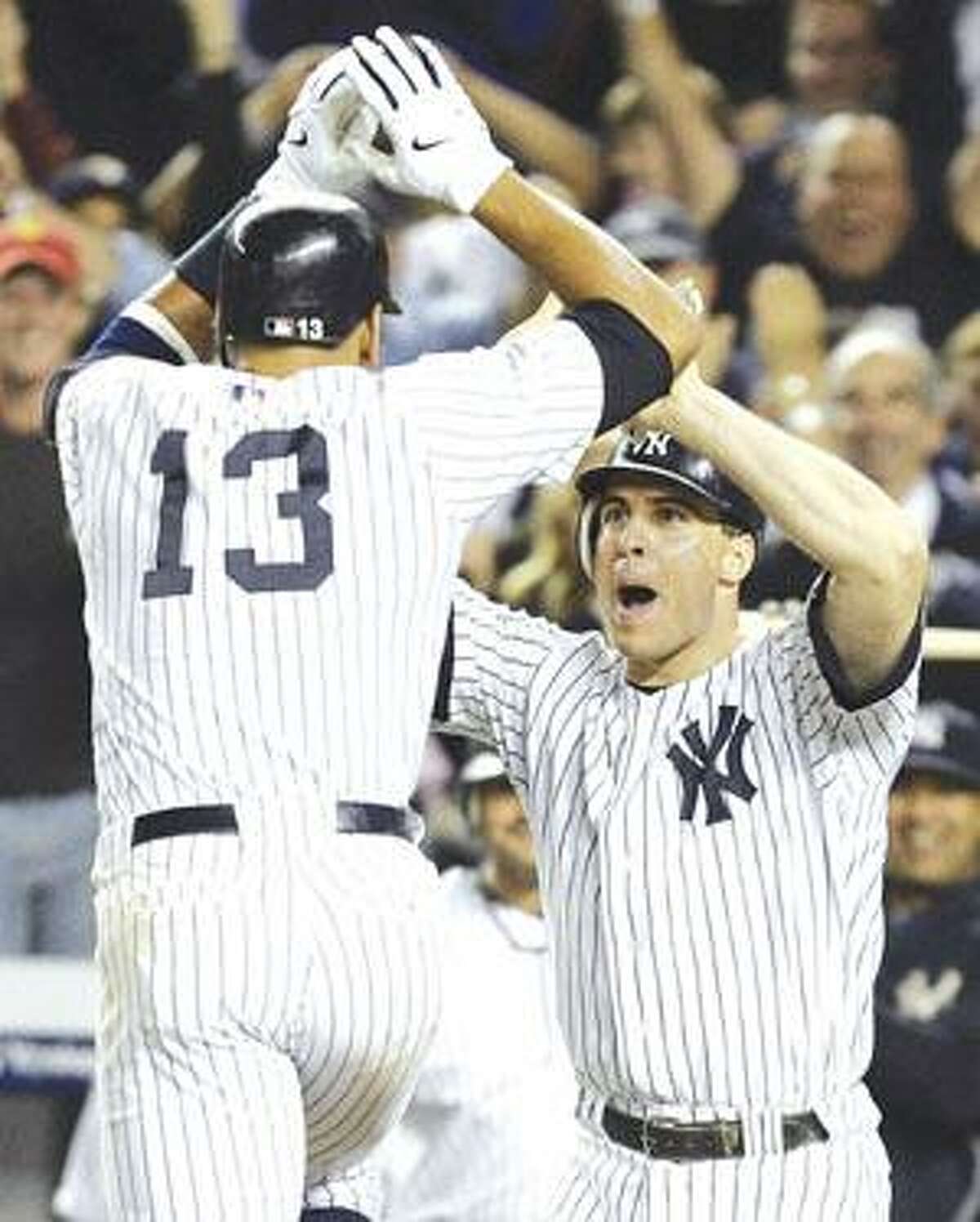 New York Yankee Alex Rodriguez, left, celebrates with teammate Mark Teixeira after hitting a ninth inning two-run home run against the Minnesota Twins in Game 2 of the American League division series at Yankee Stadium in New York Friday.