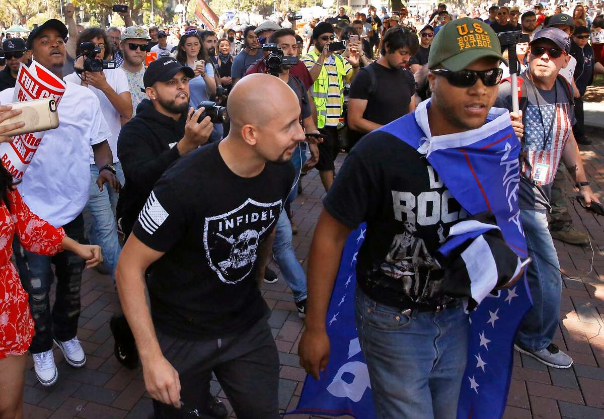 Three conservative rally attendees are pursued by a large, angry crowd of protesters on August 27, 2017 in Berkeley.