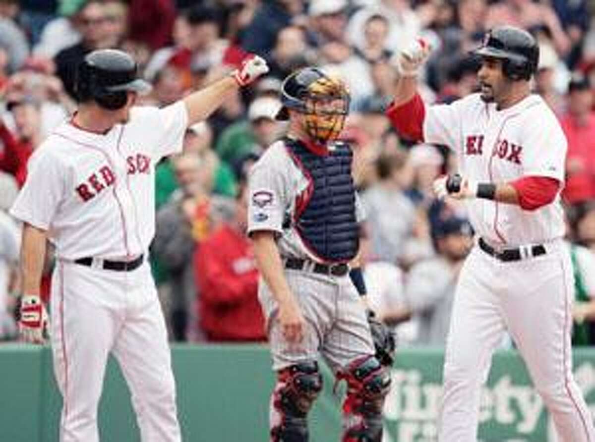 Boston Red Sox's Mike Lowell, right, celebrates his two-run home run that drove in J.D. Drew, left, as Minnesota Twins' Mike Redmond, center, looks on during the third inning of the first game of a doubleheader Wednesday in Boston.