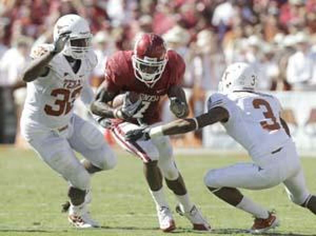 Oklahoma running back DeMarco Murray (7) runs against Texas linebacker Jordan Hicks (33) and cornerback Curtis Brown (3) during the first half of an NCAA football game at the Cotton Bowl in Dallas, Saturday, Oct. 2, 2010. (AP Photo/LM Otero)