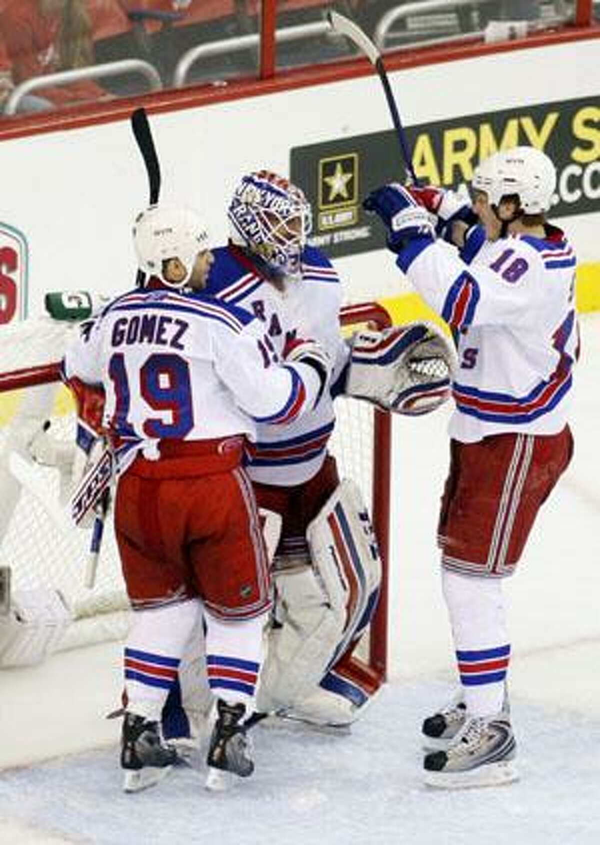 New York Rangers from left to right, Scott Gomez, Henrik Lundqvist and Marc Staal, celebrate following their win against the Washington Capitals in NHL playoff hockey in Washington, Saturday. New York won 1-0.(AP Photo/Pablo Martinez Monsivais)