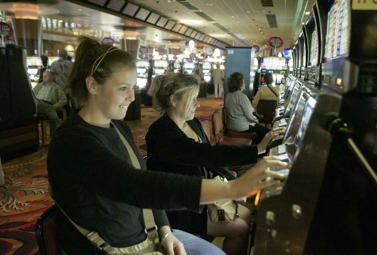 FILE - In this Aug. 30, 2009 file photo, Caitlin and Lynne Byers play the slot machines at Foxwoods Resort and Casino in Mashantucket, Conn. Foxwoods Resort Casino, one of the world's largest, has failed to make a full payment on its debt, leading to a default and another credit-rating downgrade as casinos around the country struggle amid the severe recession.(AP Photo/Bob Child, file)