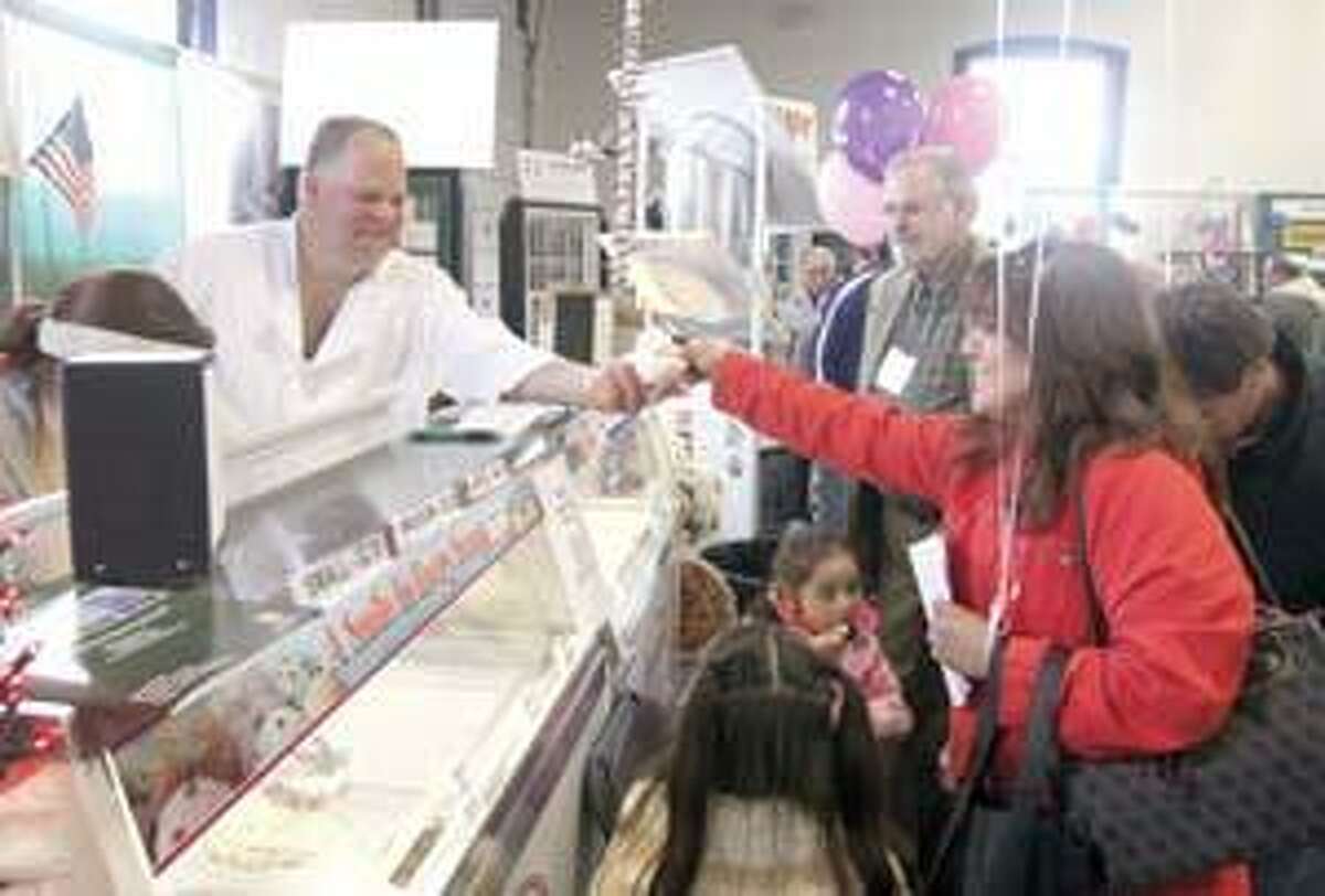 SONJA ZINKE/Register CitizenJim Amoroso, owner of Nellie's Ice Cream in Goshen, dishes out his ice cream to Leyla Peterson of Torrington Saturday at the Northwest Chamber's Home and Business Expo at the Torrington Armory. Purchase a glossy print of this photo and more at ww.registercitizen.com