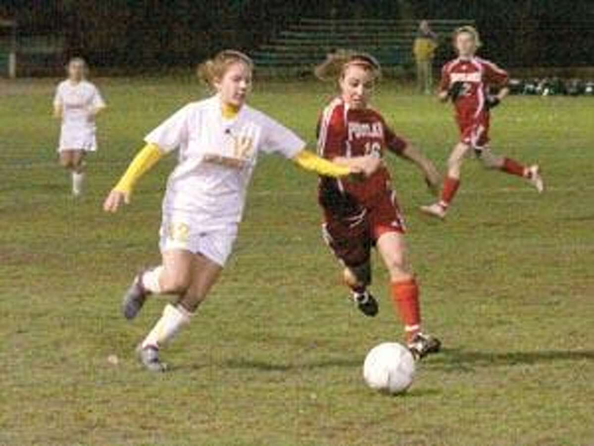 SONJA ZINKE/Register Citizen Gilbert's Rachel Wendel and Portland's Kayla Caruso fight for the ball during Wednesday evening's Class S girls soccer game at Walker Field in Winsted. Purchase a glossy print of this photo and more at www.registercitizen.com.