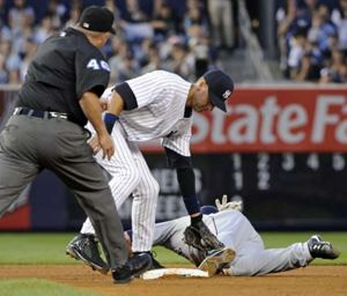 AP Umpire Ron Kulpa (46) calls Seattle Mariner runner Ryan Langerhans, right, out stealing after a tag by New York Yankees shortstop Derek Jeter during the second inning of a game Thursday at Yankee Stadium in New York.