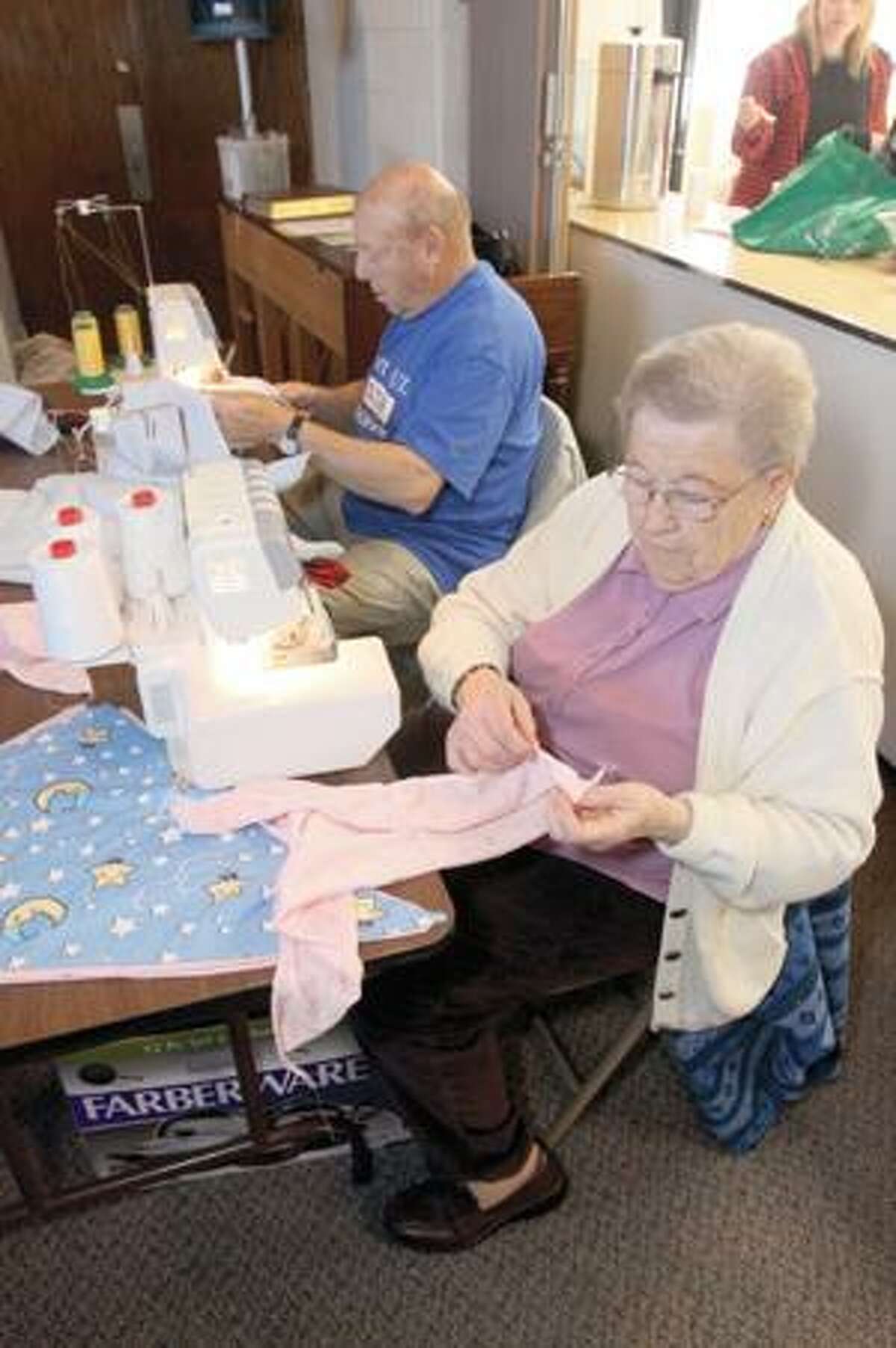 SONJA ZINKE/Register CitizenJulia Jalbert and John Mazzochi sew CUREchiefs as a host of other volunteers cut, fold and package them at the Immaculate Heart of Mary Church in Harwinton Saturday. The group is expected to make their 60,000th CUREchief Saturday. Purchase a glossy print of this photo and more at www.registercitizen.com