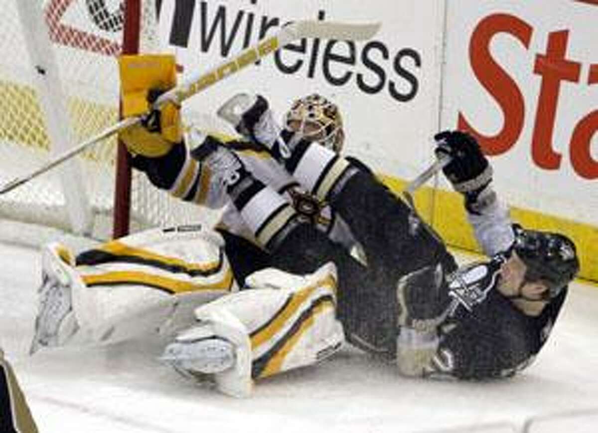 Pittsburgh Penguins' Ruslan Fedotenko, right, of Ukraine, crashes into Boston Bruins goalie Tim Thomas in the first period of an NHL hockey game in Pittsburgh, Sunday, March 7, 2010. (AP Photo/Keith Srakocic)