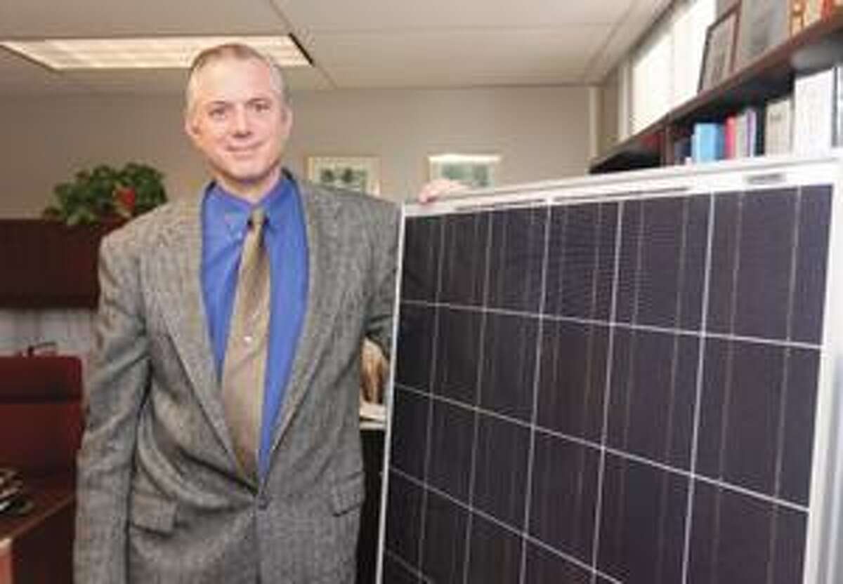 SONJA ZINKE/Register Citizen Superintendant of Schools for Regional School District 7, Clint Montgomery stands with one of the 2,000 solar panels that were installed at the school. Purchase a glossy print of this photo and more at www.registercitizen.com