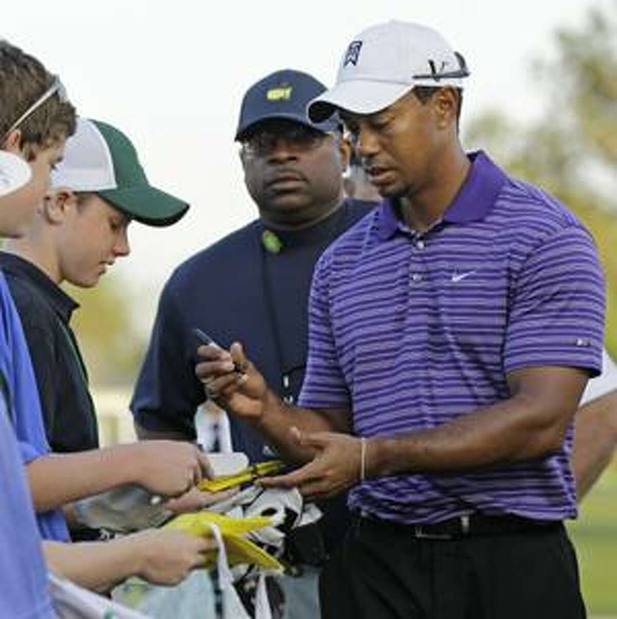 Tiger Woods signs autographs before his practice round at the Masters golf tournament in Augusta, Ga., Wednesday, April 7, 2010. The tournament begins Thursday, April, 8. (AP Photo/David J. Phillip)