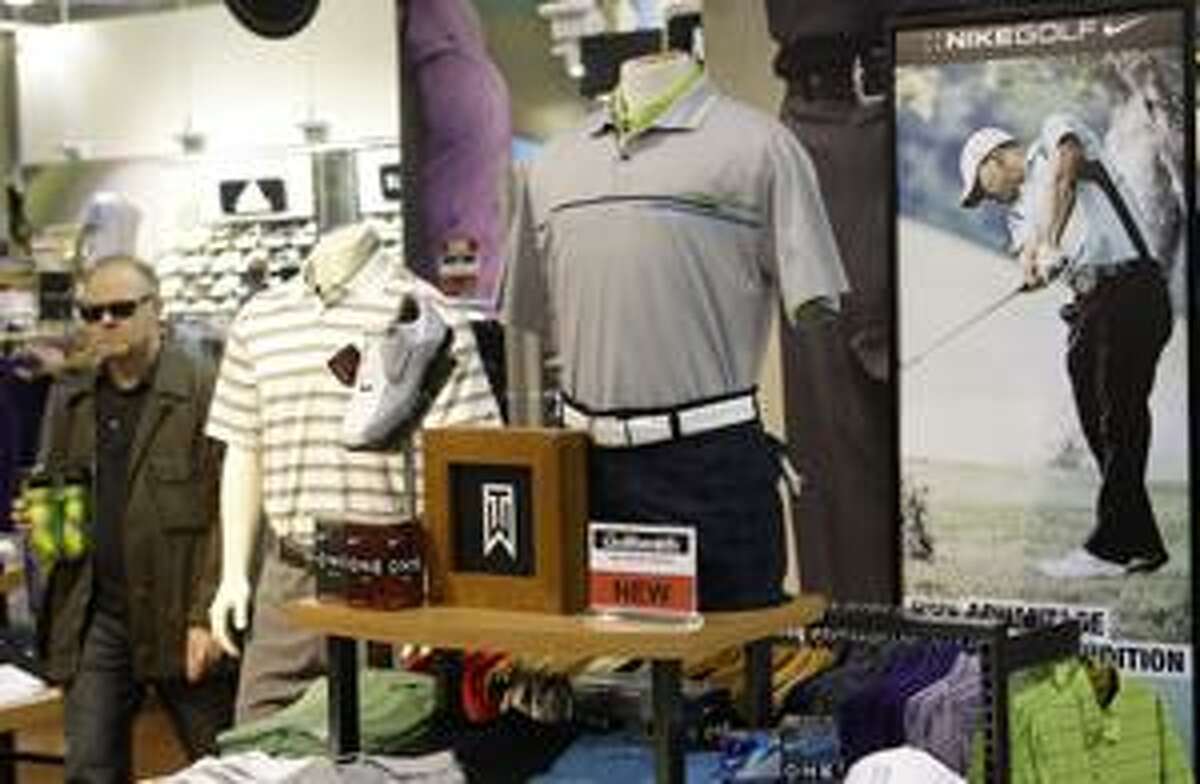 AP A shopper passes a display of Tiger Woods clothing at a Golfsmith store Wednesday in New York. Golfsmith says Woods' scandal that erupted in late November didn't dampen demand for his products.