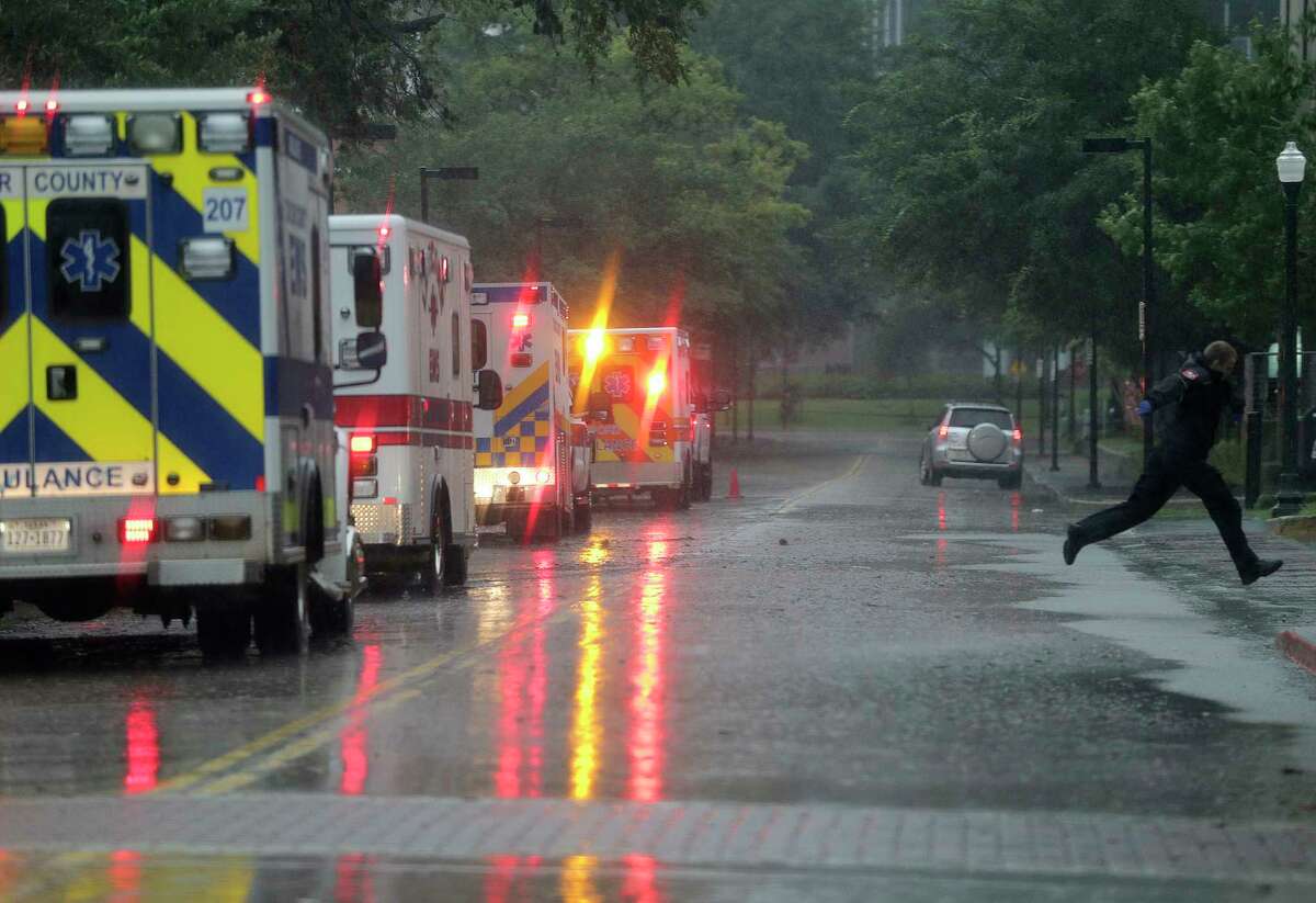 An EMT jumps over a puddle as ambulances line up to evacuate some of the ICU patients from Ben Taub Hospital on Monday.