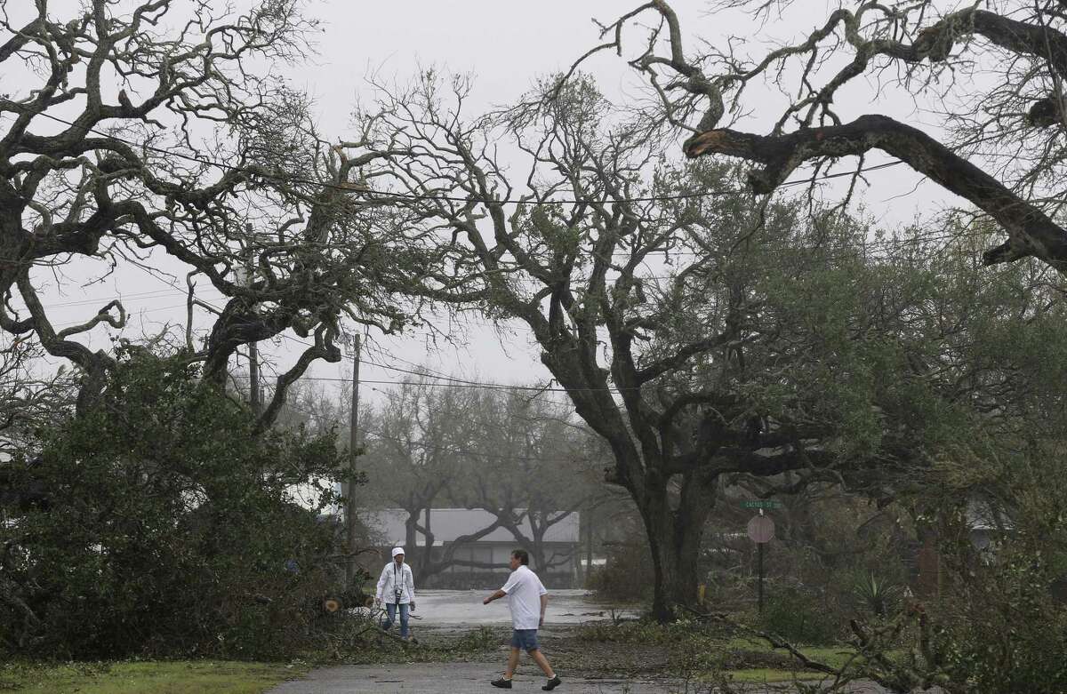 Mike Papasan, 60, and his wife, Kathryn Papasan, 58, survey the damage to their property in Fulton, Texas, Monday, August 28, 2017. Oak tress estimated to be 200-years-old, were damaged by Hurricane Harvey. Their house sustained minimal damage.