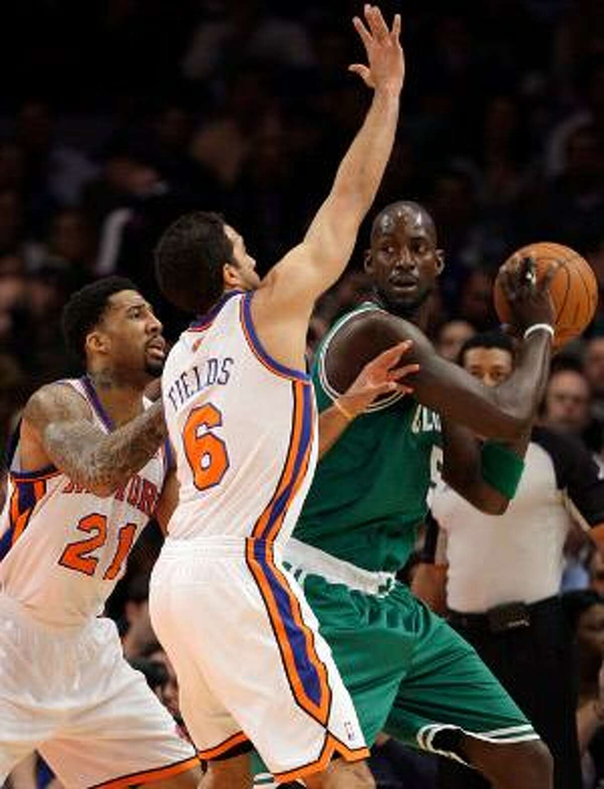 AP Boston Celtics' Kevin Garnett (5) protects the ball from New York Knicks' Landry Fields (6) and Wilson Chandler (21) during the first half of Wednesday's game in New York.