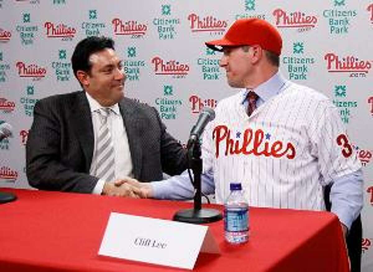 Philadelphia Phillies general manager Ruben Amaro Jr., left, and pitcher Cliff Lee shake hands after a news conference, Wednesday, in Philadelphia. Lee and the Phillies finalized a $120 million, five-year contract that brings the star pitcher back to Philadelphia. (AP Photo)