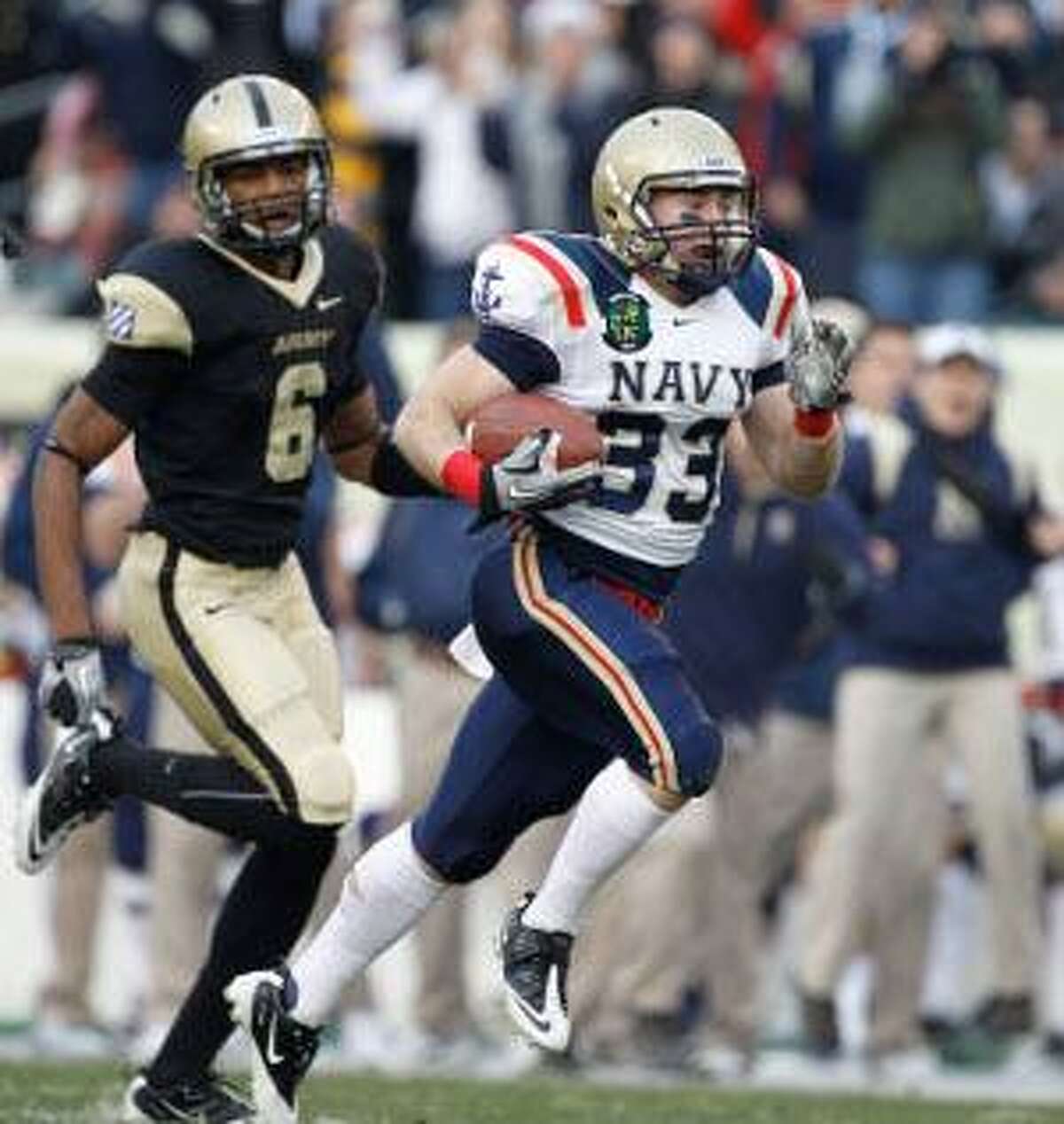 AP Navy running back John Howell, right, runs past Army cornerback Donovan Travis to score a touchdown in the first half of Saturday's game in Philadelphia. The Midshipmen won 31-17.