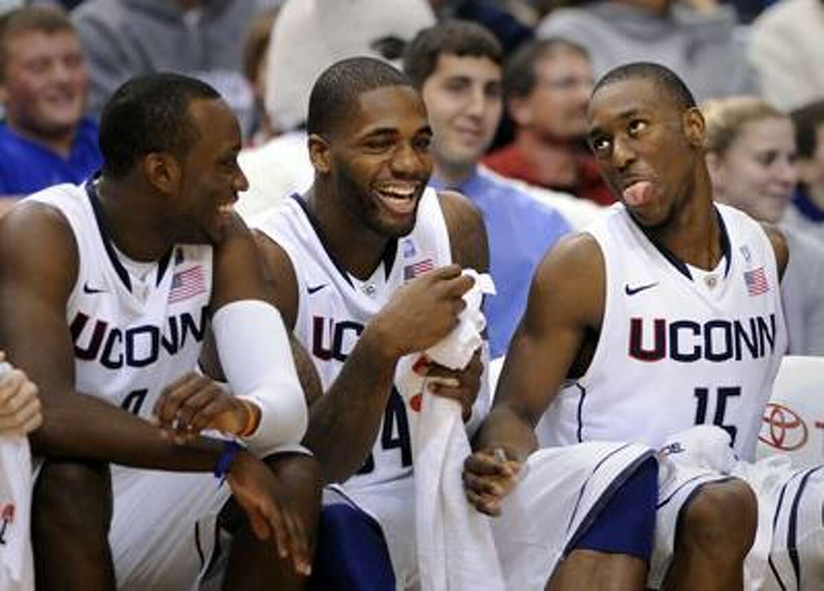 Connecticut's Kemba Walker, right, jokes with teammates Alex Oriakhi, center, and Donnell Beverly late in Connecticut's 94-61 victory over UMBC in their NCAA college basketball game in Hartford, Conn., on Friday, Dec. 3, 2010. Walker had a triple double in the win with 24 points, 13 rebounds, and 10 assists. (AP Photo/Fred Beckham)