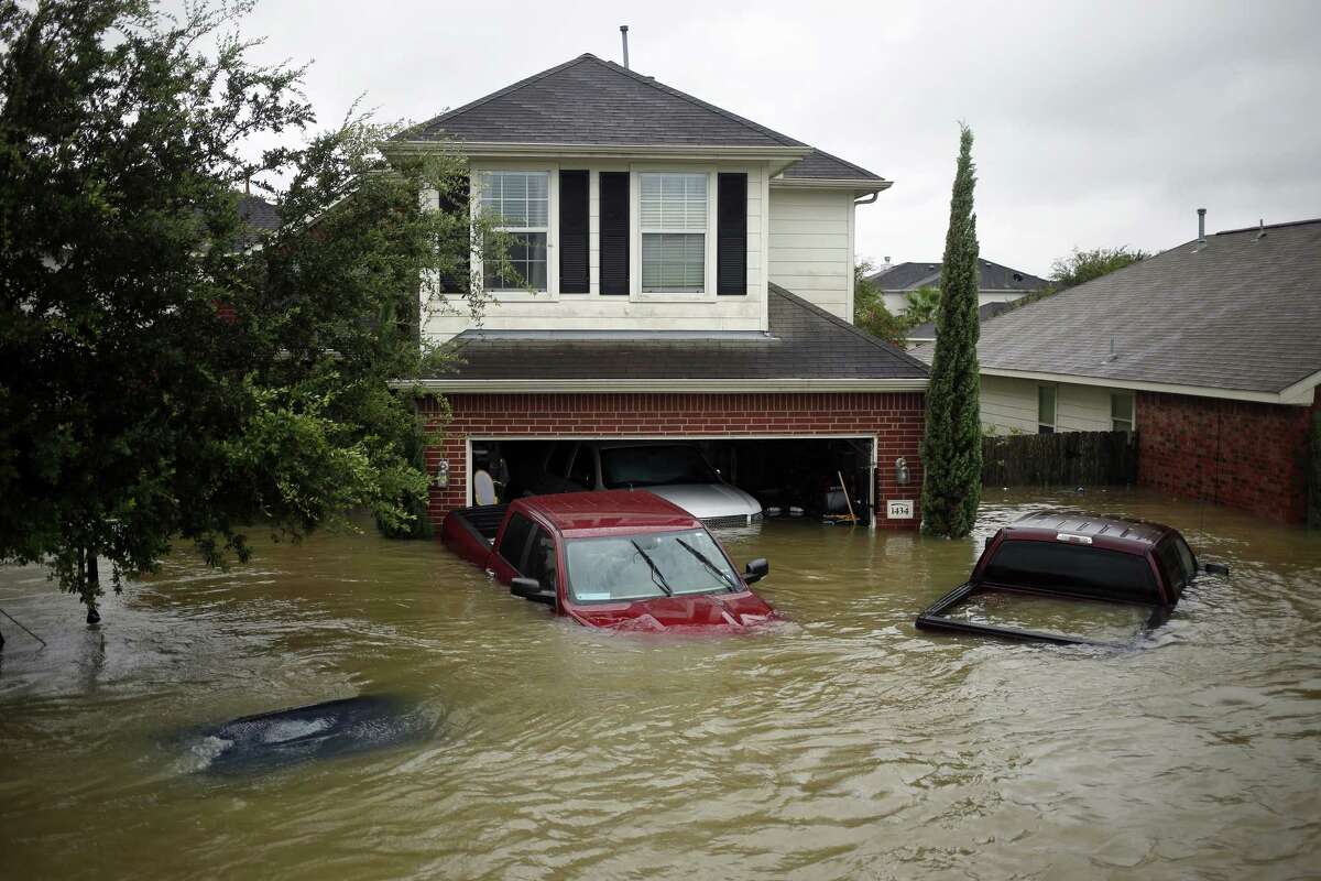 Houses and vehicles at the Highland Glen subdivision stand in floodwaters due to Hurricane Harvey in Spring, Texas, U.S., on Monday, Aug. 28, 2017. A deluge of rain and rising floodwaters left Houston immersed and helpless, crippling a global center of the oil industry and testing the economic resiliency of a state that's home to almost 1 in 12 U.S. workers. Photographer: Luke Sharrett/Bloomberg