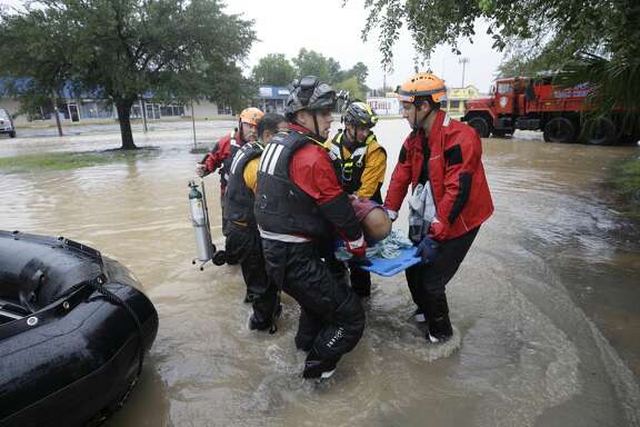 Rescuers transfer Claude Young on a back board from a boat to a pickup point along Edgebrook Sunday, August 27, 2017. The elderly man had many medical issues from a stroke in May. Flooding is wide spread after rain from Hurricane Harvey. ( Melissa Phillip / Houston Chronicle)