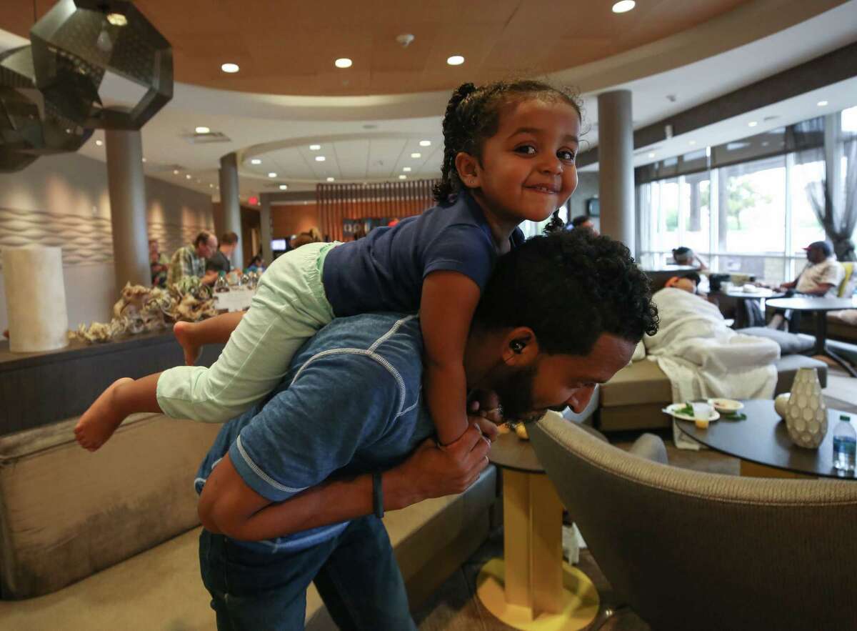 Sid Abdilahi, 31, gives his two-year-old niece, Bamas, a piggyback ride inside the Spring Hill Suites hotel Tuesday, Aug. 29, 2017, in Rosenberg, Texas. 