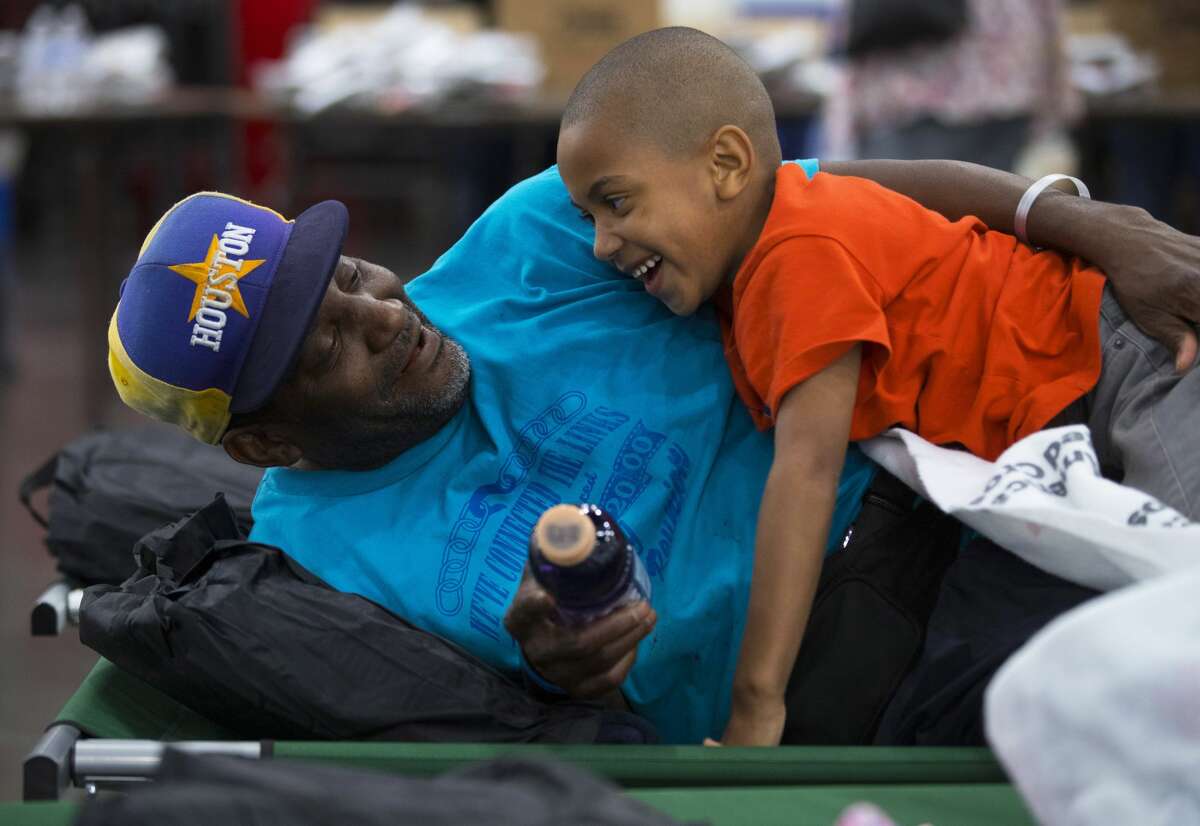 Flood evacuee from Houston's 5th Ward Korbey Haley shares a light moment with his son Jordan Haley, 6, at the George R. Brown Convention Center, which has been turned into a shelter run by the American Red Cross to house victims of the high water from Hurricane Harvey on Aug. 28, 2017 in Houston. Harvey, which made landfall north of Corpus Christi late Friday evening, is expected to dump upwards to 40 inches of rain in areas of Texas over the next couple of days.
