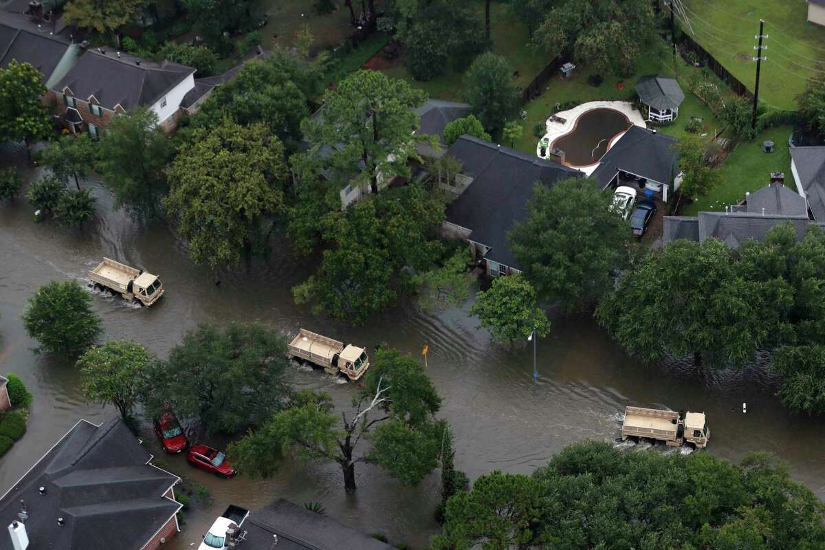 Rescue vehicles drive through a neighborhood off Cypress Creek as floodwaters rise from Tropical Storm Harvey on Tuesday, Aug. 29, 2017, in Houston.
