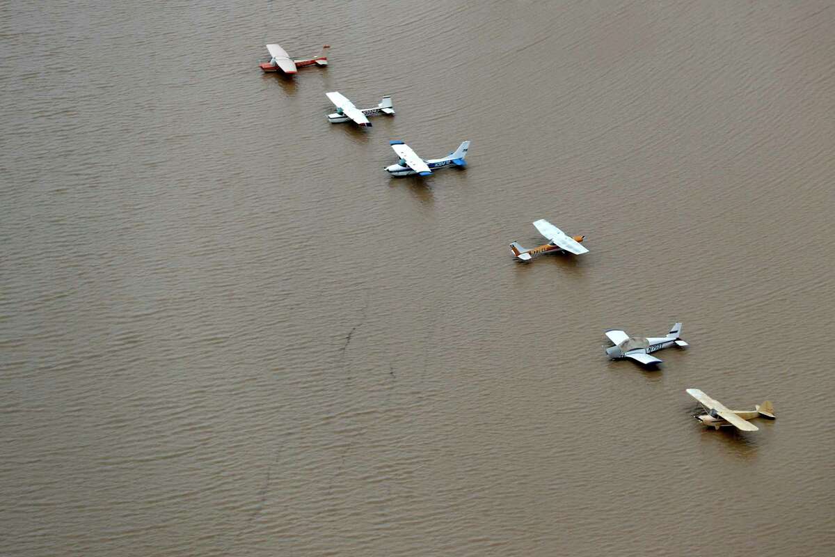 A line of airplanes are surrounded by floodwaters from Tropical Storm Harvey on Tuesday, Aug. 29, 2017, in Houston.